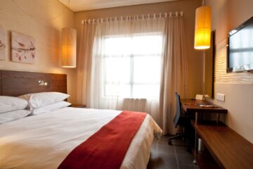 Classic King room with king bed, work desk and pendant lights at Metcourt Umfolozi, Empangeni