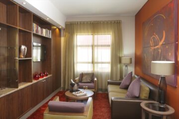 Executive Suite lounge with leather sofa, bookshelf and abstract artwork at Metcourt Umfolozi, Empangeni